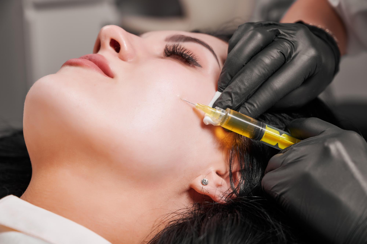 Woman receiving a PRP facial injection treatment at a clinic.